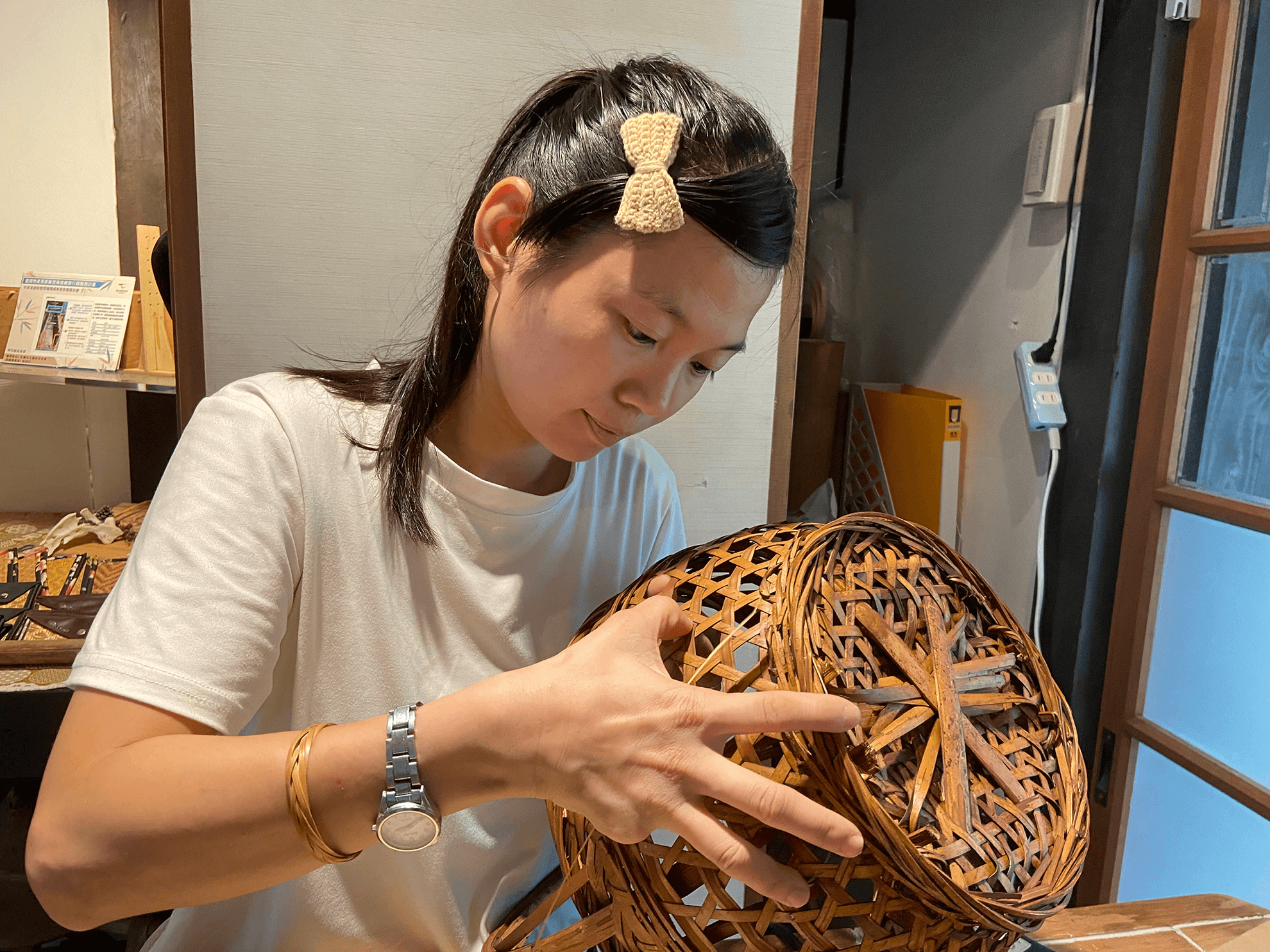 一位女子在編織著竹藝品